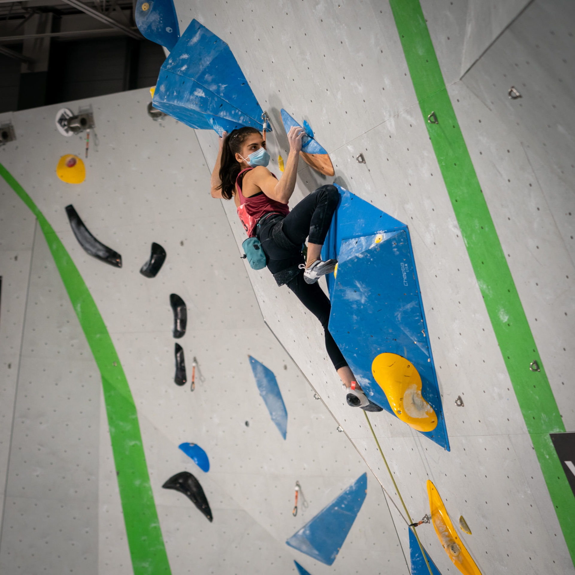 Female climbing competitor on wall